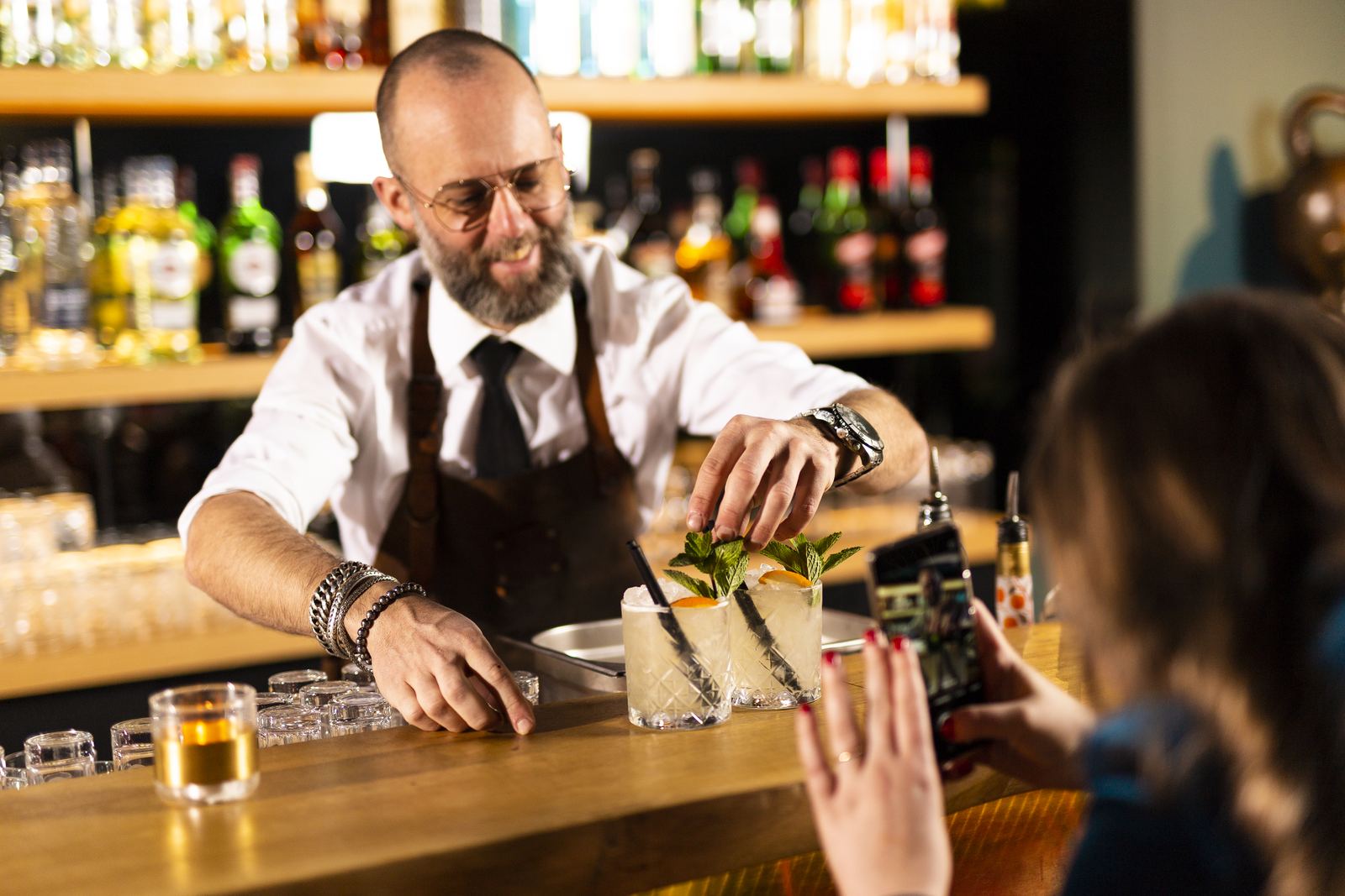 Bartender serveert een drankje aan de hotelbar